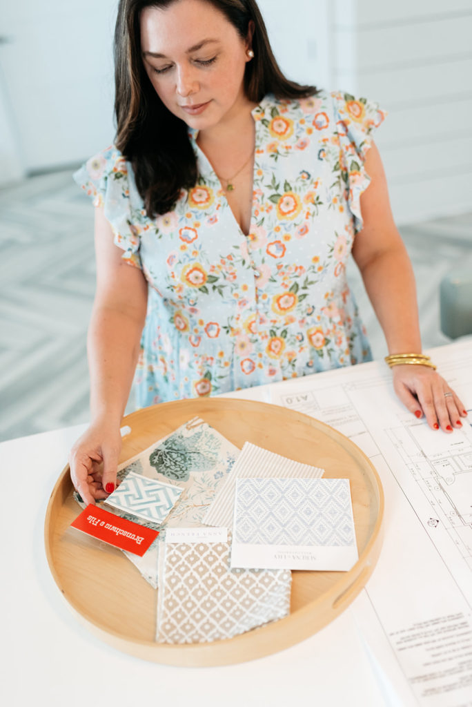 Nicole Hart, interior designer in Pawleys Island, SC reviewing interior design project materials for a timeless polished aesthetic